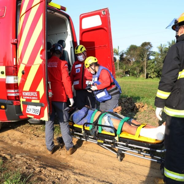 bombeiros voluntários, na porta da ambulância, fazem atendumento pré-hospitalar